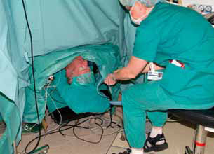 Bilde 4: Anestesisykepleier har hodet til pasienten helt nede ved golvet.